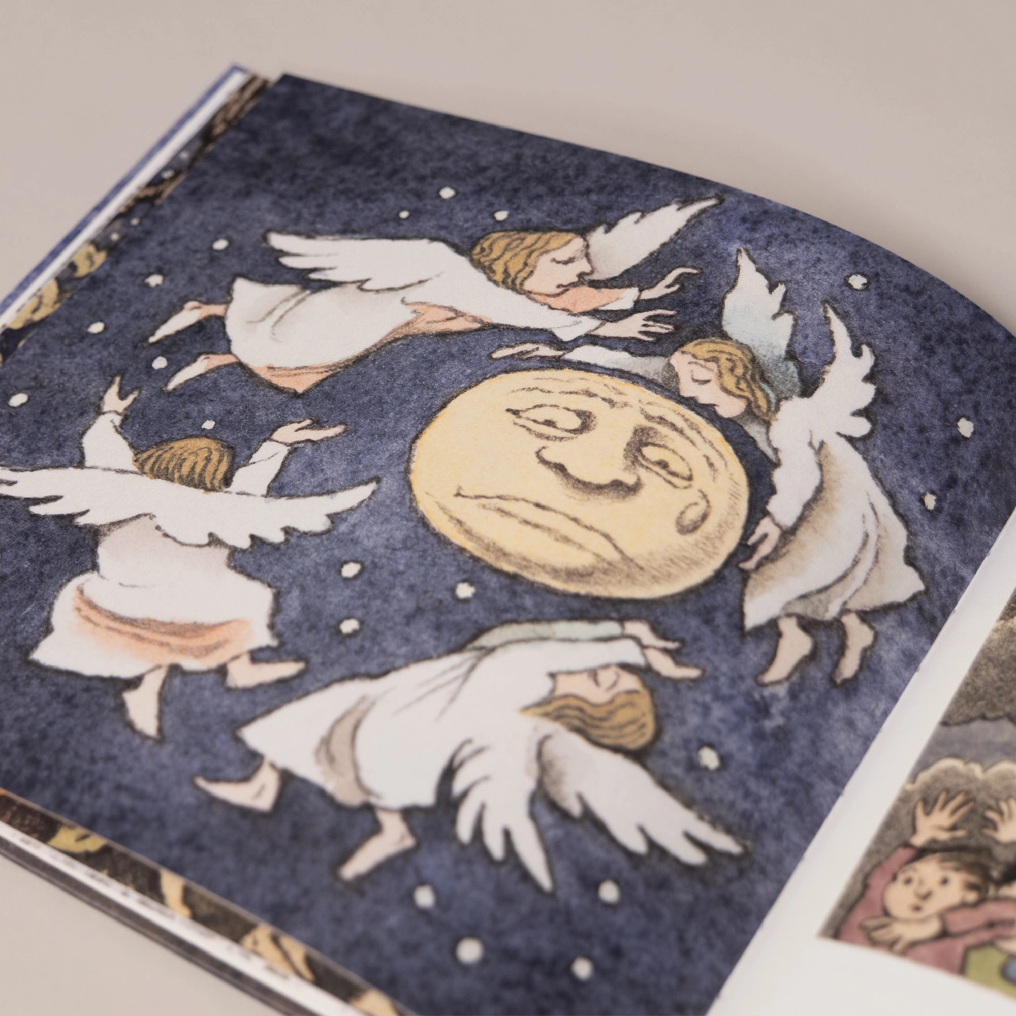 An interior illustration of a crying moon surrounded by angels